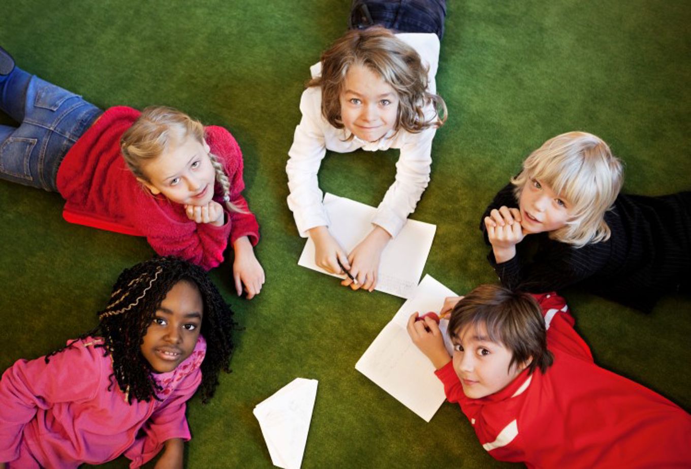 Foto: NTB scanpix Credit: Oslo kommune Barn ligger på gulvet og tegner.