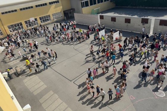 en gruppe mennesker som står på et betongområde ved siden av en bygning