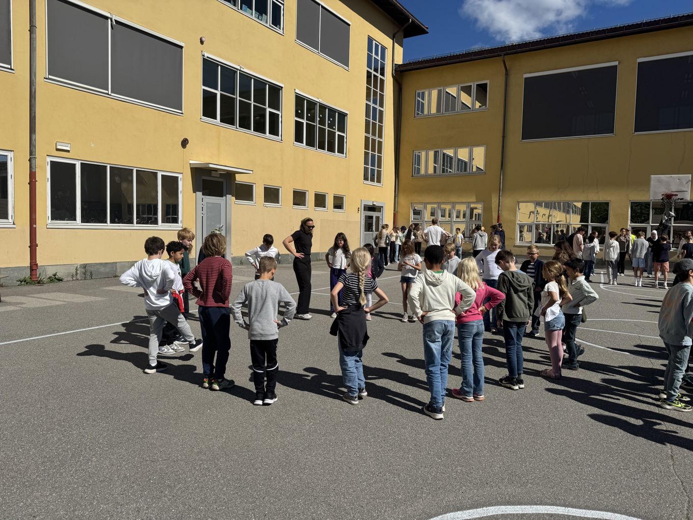 En gruppe mennesker som står på en parkeringsplass En gruppe mennesker som står på en parkeringsplass