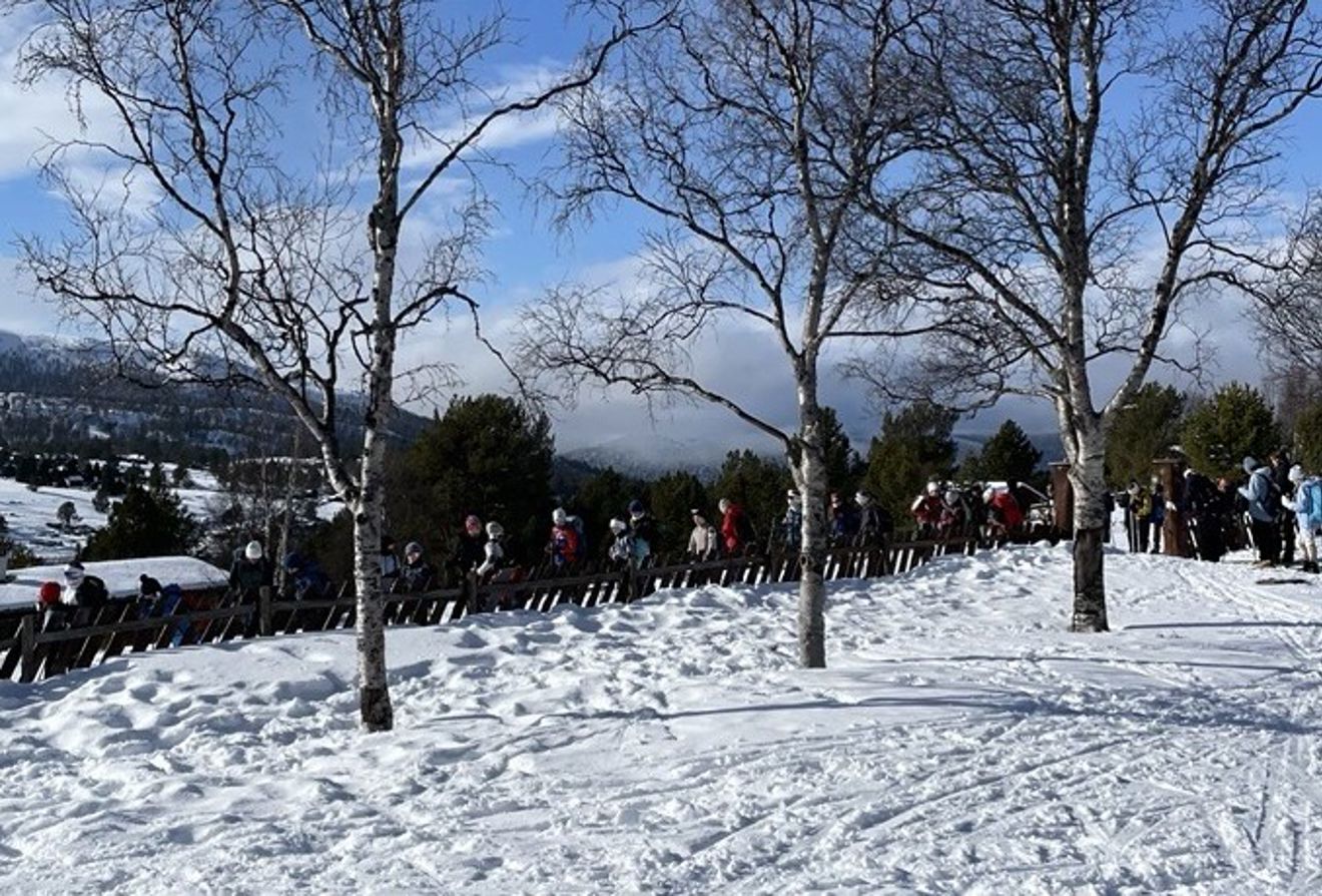 En gruppe mennesker som står på en snødekt ås