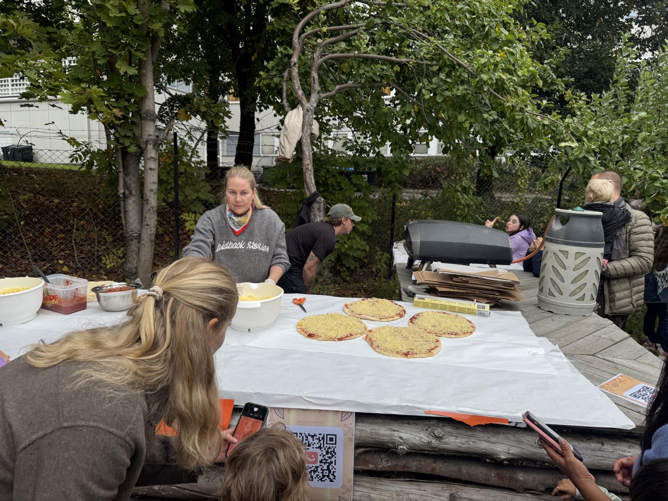 en gruppe mennesker som sitter ved et bord med mat på en gruppe mennesker som sitter ved et bord med mat på