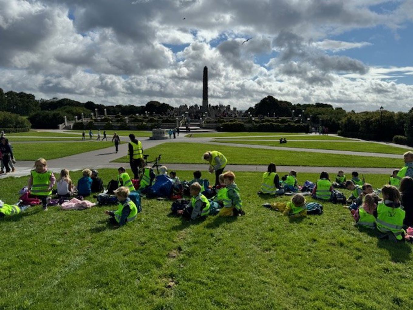 en gruppe mennesker som sitter på gresset